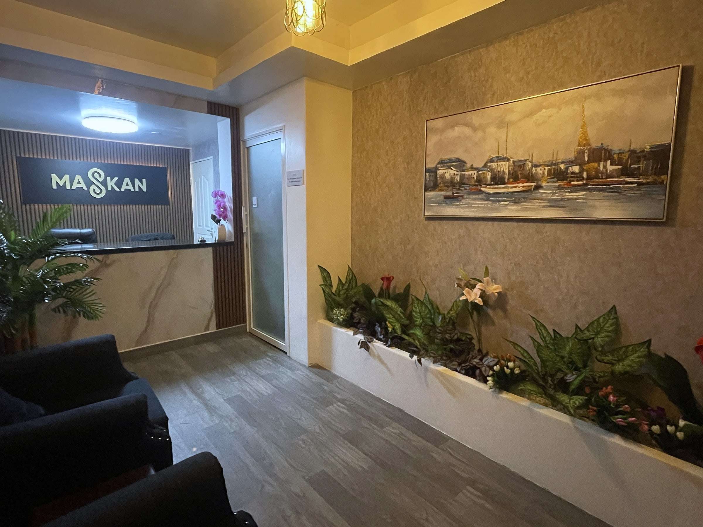 Guest lounge with a planter of fresh flowers and a painting