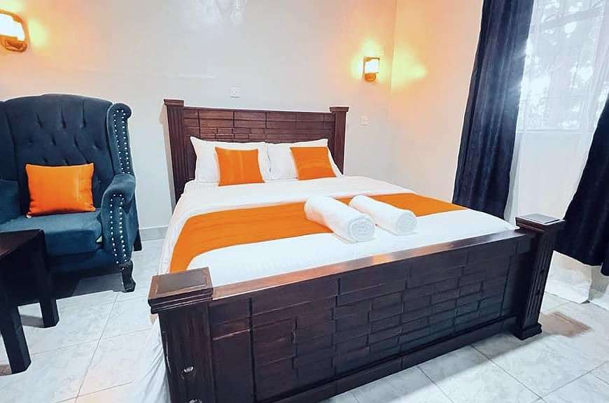 Superior room bed with rolled towels, beside the wingback armchair