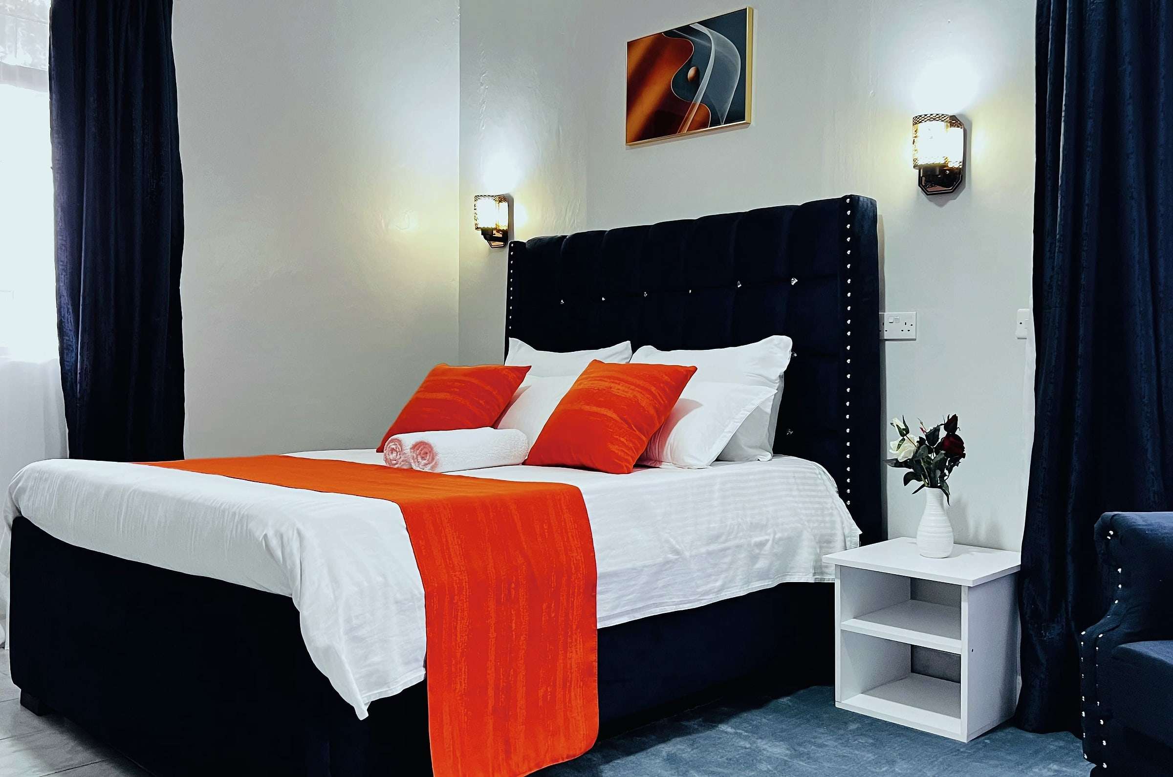 VIP room with a tufted headboard, white linen and an orange throw
