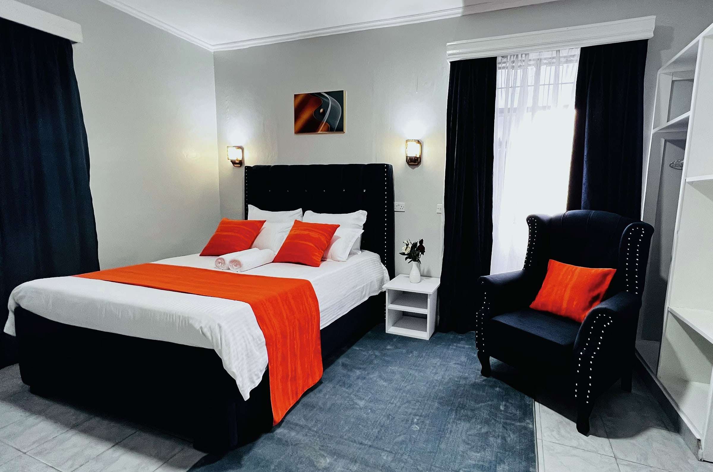VIP room with wingback armchair, bedside table and wardrobe